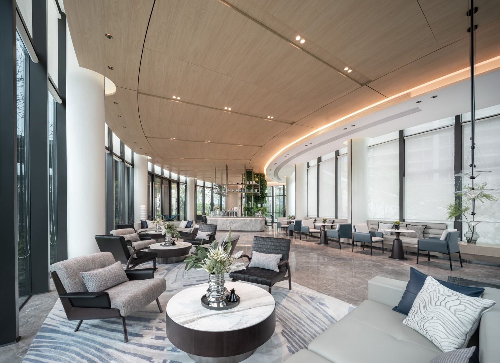 Hotel lounge with curved timber ceiling, cove lighting and marble floors